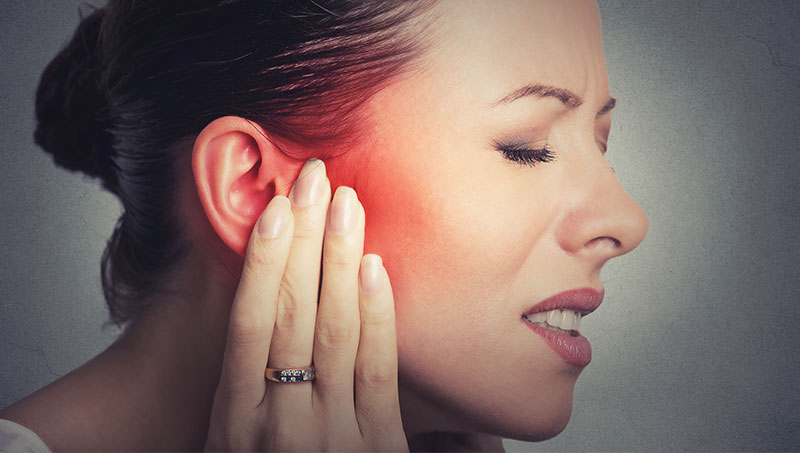 Woman suffering with inner ear pain